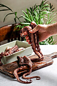 fresh octopus, holding male hands, direct sunlight