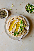 Cremiger Hummus-Dip mit Gurke und Olivenöl-Flatlay