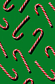 Pattern of Christmas candies cane stick on green background