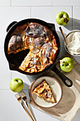Deutscher Apfelpfannkuchen mit Pfanne und Tellern