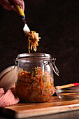 Healthy Korean-style probiotic kimchi in a glass jar, close-up against a dark background