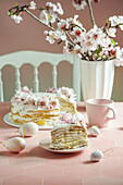 Krepptorte oder Blini-Torte für die Osterfeier, rosafarbener Hintergrund, Mandelblüten