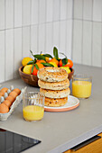 Morgenbrötchen in der Küche mit Orangensaft, Eiern und Zitrusfrüchten