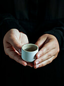 The small glass with Japanese sake held by human hands