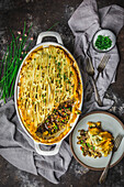 Shepherd's pie, topped with mashed potato and chives and served on a plate