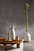 Japanese sake still life with a bamboo branch, light-coloured linen background, Asian ceremony