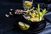 Healthy celery salad with apples and seeds served in the bowl in dark background