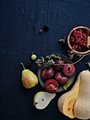 Herbstliche Lebensmittelzutaten auf dunkelblauem Hintergrund mit Kopierraum. Flat-Lay von Herbstgemüse, Beeren und Pilzen vom lokalen Markt. Vegane Zutaten