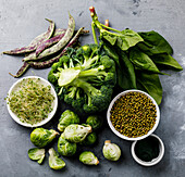 Healthy Green food Clean eating selection Proteinquelle für Vegetarier: Rosenkohl, Brokkoli, Spinat, Spirulina auf grauem Betonhintergrund
