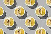 Horizontal pattern of fresh half pomelo fruit on a grey background flatlay food