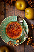 An individual serving of classic British Malvern Pudding with stewed apples and custard.