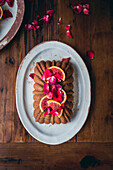 Blood orange cake on a plate against a wooden table