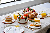 Breakfast tablescape with pastries, orange juice and fruit