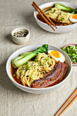 Ramen, Pork Belly, Bok Choy and Egg with a Light Neutral Background