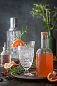 Club soda in vintage glass on tray with blood orange syrup with citrus and rosemary garnish