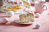 crepe cake or blini cake for Easter party, rose pink background, almond flowers