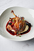 Roasted, confit duck leg, parsnip puree, chipolata of spiced pork and fennel seeds, roasted fennel bulb, duck jus, boysenberries