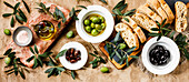 Italian food with olives, ciabatta slices and olive oil on a travertine background Copy surface