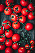 Rote Kirschtomaten auf einem hölzernen Hintergrund