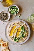 Cremiger Hummus-Dip mit Gurke und Olivenöl-Flatlay