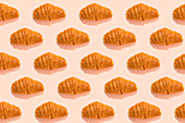 Croissant-Muster auf rosa Hintergrund