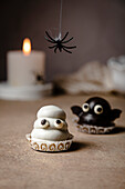 Ghost and bat sweets over table for Halloween; made with cookie base, dulce de leche fill and chocolate coating