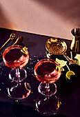Ein kosmopolitischer Cocktail in einem traditionellen Glas, auf einer schwarzen Bar