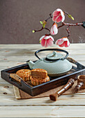 Mooncake for Mid-Autumn Festival, concept of traditional festive chinese food on an Asian wooden tray with teapot