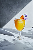 Orange juice with garnish and white grey background and shadow