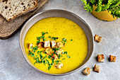 Zucchini cream soup. The dish is served with diced crutons. Top view.