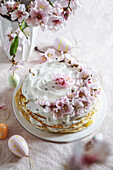 Krepptorte oder Blini-Torte für Osterfest, rosa Hintergrund, Mandelblüten, rosa Hintergrund, Frauenhände