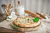 Eine rustikale Carbonara-Pizza auf einem Holzschneidebrett