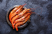 Raw fresh Prawns Langostino Austral on metal plate on black background