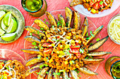 Vegetarian three-bean chilli fries on a pink background