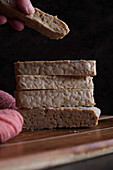 Slices of Indonesian-style fermented tempeh against a dark background