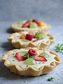 Fresh fruit and custard cream cake decorated with mint leaves