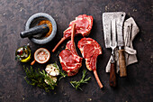 Raw fresh veal ribs with ingredients and vintage kitchen utensils on a dark background