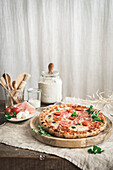 Schinken-Mozzarella-Pizza auf einem Schneidebrett