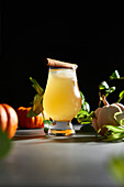 Fresh cider with pumpkins against a dark background