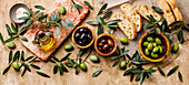 Italian food with Olives, Sliced bread Ciabatta and Olive Oil on travertine background