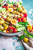 Köstlicher Salat Nicoise mit frischem Gemüse in einem Tablett auf dem Tisch (von oben)