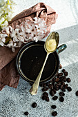 Tasse kugelsicherer ketogener Kaffee in einem Keramikbecher auf einem Betontisch an einem sonnigen Morgen