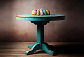 Tasty colorful Easter eggs placed on blue wooden table against brown background