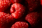 Frische, süße, rote Himbeeren im Hintergrund, die zusammen das Konzept der gesunden Ernährung darstellen
