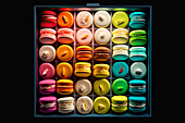 Generative AI illustration top view of various tasty macaroons placed in row against black background