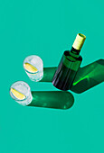 Ein stilvoller Gin-Tonic-Cocktail in einem Glas mit einer Limettenscheibe, präsentiert vor einem grünen Hintergrund mit scharfen Schatten