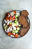 From above vegetable salad in Greek style with feta cheese on concrete background