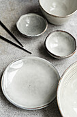 Set of grey ceramic crockery on a concrete background in the same color