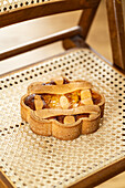 An Italian Easter pastiera napoletana pie, rich with citrus flavors, sits on a rattan chair