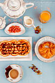 Draufsicht auf ein kontinentales Frühstücksarrangement mit Waffeln, Früchten, Kaffee und Saft, serviert auf einer blauen Fläche